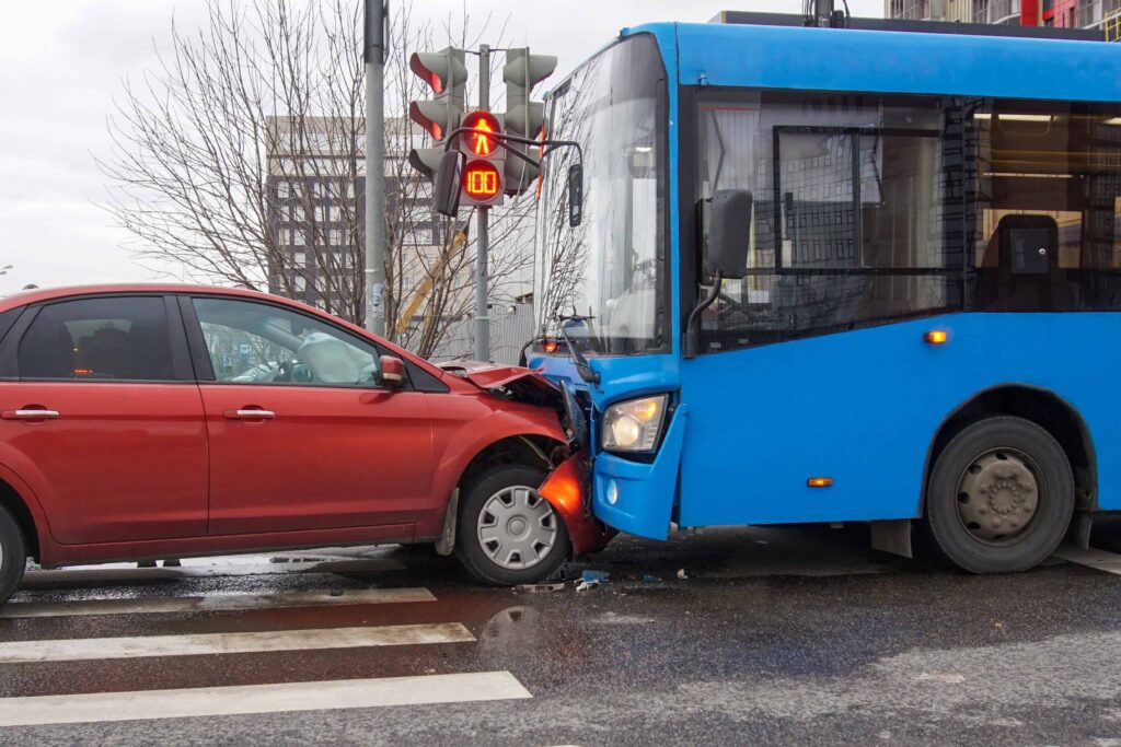 Car and city bus collision at intersection, representing public transportation accident and vehicle crash claim.