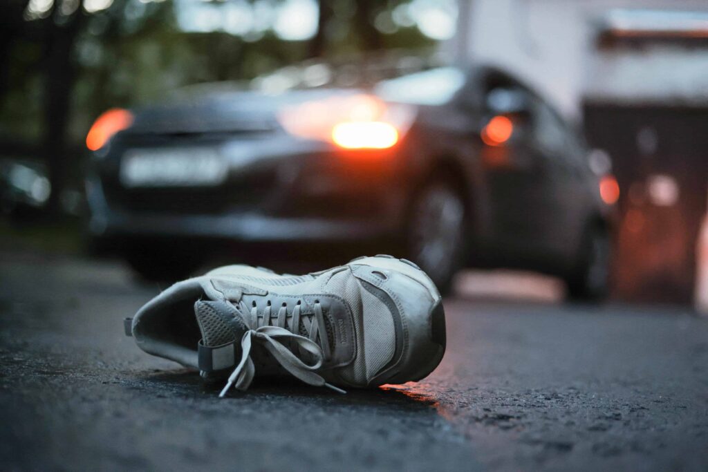 Abandoned shoe on the road after a car accident, symbolizing pedestrian injury and hit-and-run accident scene. Abandoned shoe on the road after a car accident, symbolizing pedestrian injury and hit-and-run accident scene.
