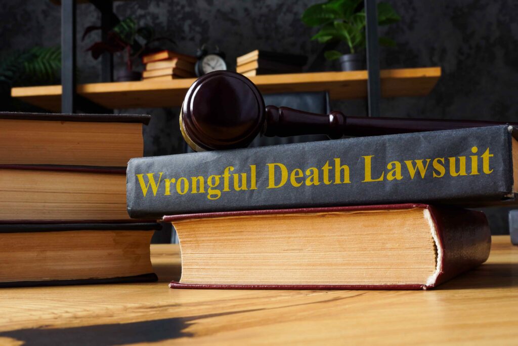 Wrongful death lawsuit book with judge&rsquo;s gavel on stack of law books, symbolizing fatal accident claim and legal action.