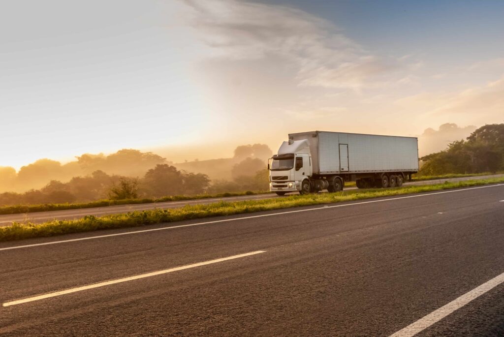 Semi truck driving on highway at sunrise, freight transportation and logistics concept Semi truck driving on highway at sunrise, freight transportation and logistics concept